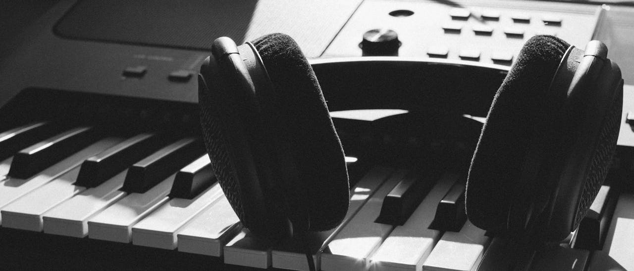 discover Close-up of headphones resting on piano keys, capturing the essence of music creation.